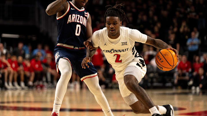 Cincinnati Bearcats guard Jizzle James (2) drives on Arizona Wildcats guard Jaden Bradley (0) in the second half of the NCAA basketball game at the Fifth Third Arena in Cincinnati on Saturday, January 4, 2025.