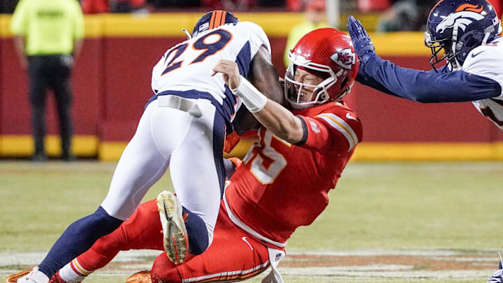 Oct 12, 2023; Kansas City, Missouri, USA; Kansas City Chiefs quarterback Patrick Mahomes (15) is tackled by Denver Broncos cornerback Ja'Quan McMillian (29) and cornerback Fabian Moreau (23) during the first half at GEHA Field at Arrowhead Stadium. 