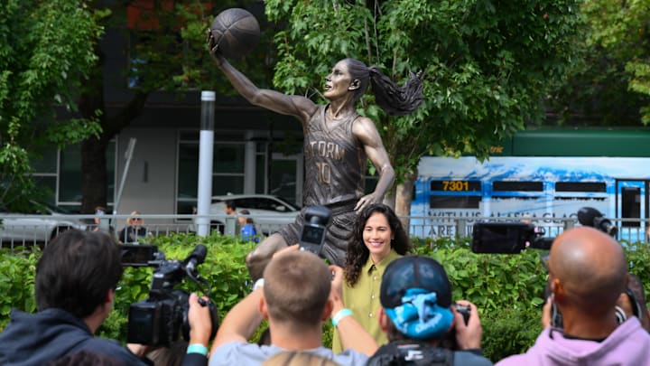 Aug 17, 2025; Seattle, Washington, USA; Former Seattle Storm player, Sue Bird, poses for a photo in front of her statue prior to the game between the Seattle Storm and the Phoenix Mercury at Climate Pledge Arena. 