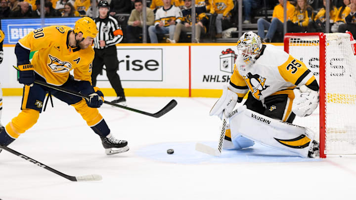 Dec 19, 2024; Nashville, Tennessee, USA;  Pittsburg Penguins goaltender Tristan Jarry (35) blocks the shot of Nashville Predators center Ryan O'Reilly (90) during the first period at Bridgestone Arena. Mandatory Credit: Steve Roberts-Imagn Images
