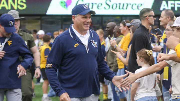 Sep 27, 2025; Morgantown, West Virginia, USA; West Virginia Mountaineers head coach Rich Rodriguez walks on the field and greets fans before their game against the Utah Utes at Milan Puskar Stadium. Mandatory Credit: Ben Queen-Imagn Images