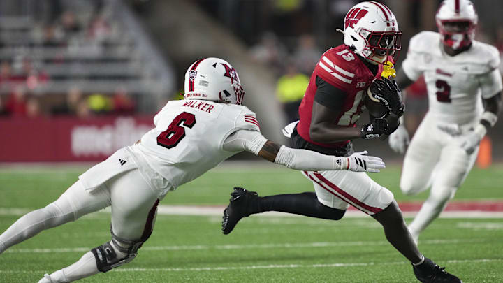 Aug 28, 2025; Madison, Wisconsin, USA; Wisconsin Badgers wide receiver Eugene Hilton Jr. (13) rushes with the football against Miami (OH) RedHawks defensive back Adrian Walker Jr. (6) during the third quarter at Camp Randall Stadium. Mandatory Credit: Jeff Hanisch-Imagn Images Aug 28, 2025; Madison, Wisconsin, USA; Wisconsin Badgers wide receiver Eugene Hilton Jr. (13) rushes with the football against Miami (OH) RedHawks defensive back Adrian Walker Jr. (6) during the third quarter at Camp Randall Stadium. Mandatory Credit: Jeff Hanisch-Imagn Images