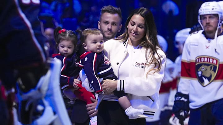 Johnny Gaudreau's wife Meredith walks out onto the ice with her children for a memorial for Johnny and Matthew Gaudreau.