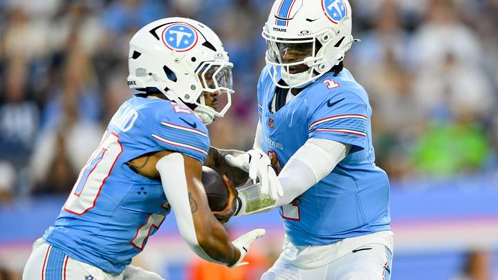 Titans quarterback Cam Ward hands the ball off to running back Tony Pollard.