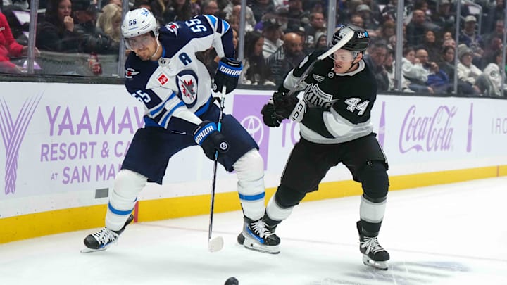 Nov 27, 2024; Los Angeles, California, USA; Winnipeg Jets center Mark Scheifele (55) and LA Kings defenseman Mikey Anderson (44) battle for the puck in the first period at Crypto.com Arena. Mandatory Credit: Kirby Lee-Imagn Images