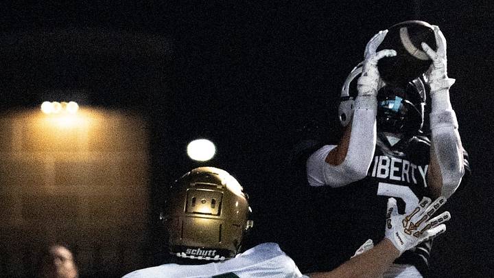 Iowa City Liberty’s Cooper Lester (7) catches the football for a touchdown as Iowa City West’s Carter Spark (3) defends Sept. 25, 2026 at Iowa City Liberty High School in North Liberty, Iowa.
