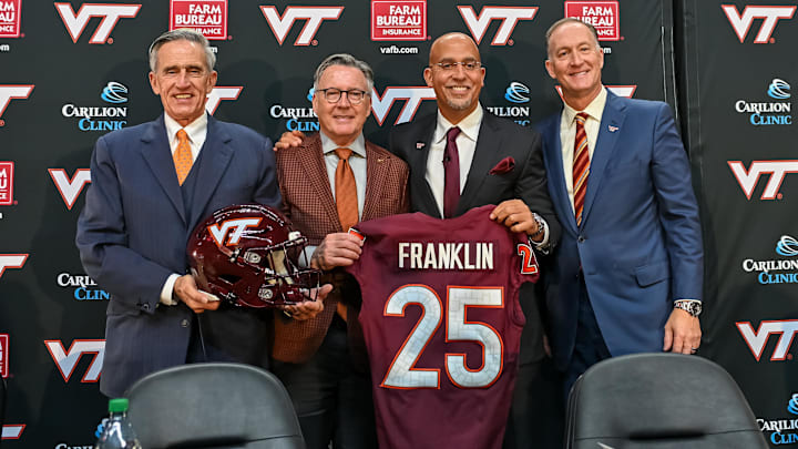 Nov 19, 2025; Blacksburg, VA, USA;  L-R, John Rocovich, Timothy Sands, James Franklin and Whit Babcock hold up a Virginia Tech jersey during the press conference celebrating Franklin as head coach at Cassell Coliseum. Mandatory Credit: Brian Bishop-Imagn Images