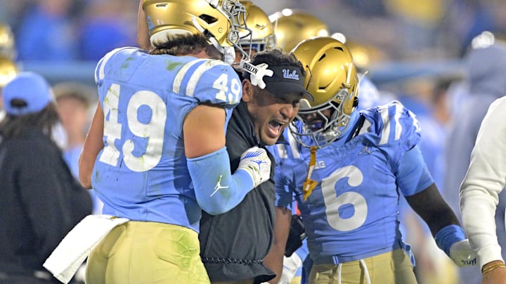 Nov 8, 2024; Pasadena, California, USA;   UCLA Bruins defensive coordinator Ikaika Malloe, center, celebrates with linebacker Carson Schwesinger (49) defensive back Jaylin Davies (6) after an interception in the second half against the Iowa Hawkeyes at the Rose Bowl. Mandatory Credit: Jayne Kamin-Oncea-Imagn Images