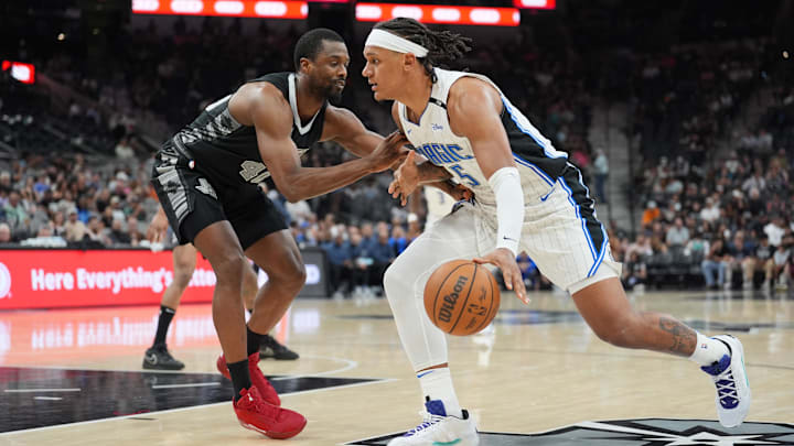Apr 1, 2025; San Antonio, Texas, USA;  Orlando Magic forward Paolo Banchero (5) dribbles against San Antonio Spurs forward Harrison Barnes (40) in the second half at Frost Bank Center. Mandatory Credit: Daniel Dunn-Imagn Images