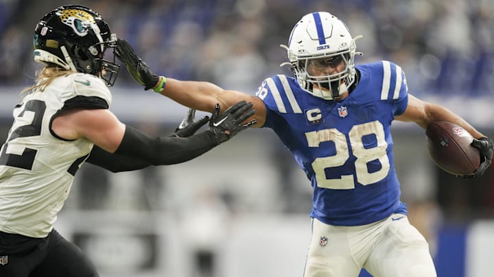 Jan 5, 2025; Indianapolis, Indiana, USA; Indianapolis Colts running back Jonathan Taylor (28) pushes off Jacksonville Jaguars cornerback De'Antre Prince (24) as he rushes the ball during a game against the Jacksonville Jaguar at Lucas Oil Stadium. Mandatory Credit: Grace Hollars/USA TODAY Network via Imagn Images