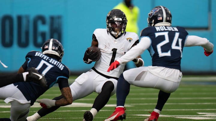 Jacksonville Jaguars running back Travis Etienne Jr. (1) is bottled-up for a loss by Tennessee Titans cornerback Elijah Molden (24) during their game at Nissan Stadium in Nashville, Tenn., Sunday, Jan. 7, 2024. Jacksonville Jaguars running back Travis Etienne Jr. (1) is bottled-up for a loss by Tennessee Titans cornerback Elijah Molden (24) during their game at Nissan Stadium in Nashville, Tenn., Sunday, Jan. 7, 2024.