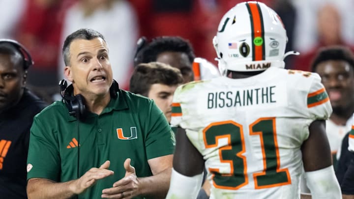 Jan 19, 2026; Miami Gardens, FL, USA; Miami Hurricanes head coach Mario Cristobal with linebacker Wesley Bissainthe (31) against the Indiana Hoosiers during the College Football Playoff National Championship game at Hard Rock Stadium. Mandatory Credit: Mark J. Rebilas-Imagn Images