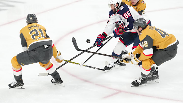 Jan 8, 2026; Las Vegas, Nevada, USA; Columbus Blue Jackets right wing Kirill Marchenko (86) loses control of the puck from a tip by Vegas Golden Knights center Brett Howden (21) as he skates between defenseman Zach Whitecloud (2) and right wing Braeden Bowman (42) during the third period at T-Mobile Arena. Mandatory Credit: Stephen R. Sylvanie-Imagn Images