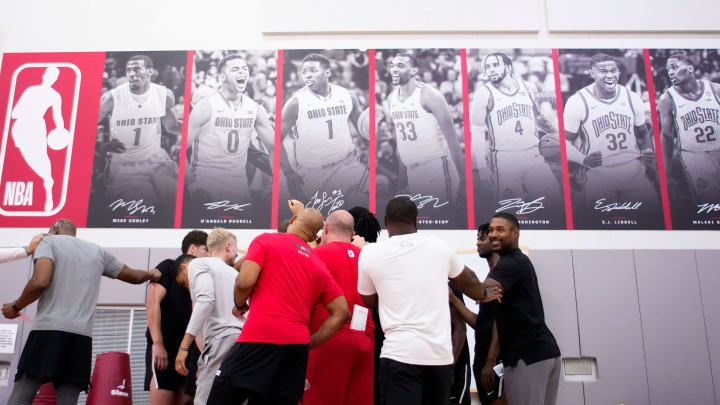 Jul 9, 2024; Columbus, OH, USA; Pictures of recent NBA players hang on the wall of the practice gym over the as the Ohio State Buckeyes men’s basketball team huddles during a summer workout in the practice gym at the Schottenstein Center. Jul 9, 2024; Columbus, OH, USA; Pictures of recent NBA players hang on the wall of the practice gym over the as the Ohio State Buckeyes men’s basketball team huddles during a summer workout in the practice gym at the Schottenstein Center.