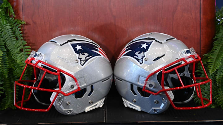 Jan 13, 2025; Foxborough, MA, USA; A pair of New England Patriots helmets sit in front of the podium before a press conference at Gillette Stadium. Mandatory Credit: Eric Canha-Imagn Images