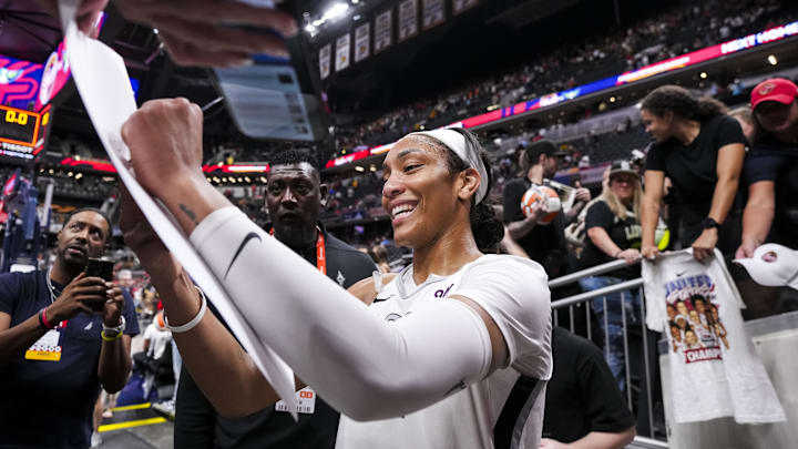 Sep 13, 2024; Indianapolis, Indiana, USA; Las Vegas Aces center A'ja Wilson (22) signs a poster Friday, Sept. 13, 2024, during a game between the Indiana Fever and the Las Vegas Aces on Friday, Sept. 13, 2024, at Gainbridge Fieldhouse in Indianapolis. The Aces defeated the Fever, 78-74. Mandatory Credit: Grace Smith/USA TODAY Network via Imagn Images Sep 13, 2024; Indianapolis, Indiana, USA; Las Vegas Aces center A'ja Wilson (22) signs a poster Friday, Sept. 13, 2024, during a game between the Indiana Fever and the Las Vegas Aces on Friday, Sept. 13, 2024, at Gainbridge Fieldhouse in Indianapolis. The Aces defeated the Fever, 78-74. Mandatory Credit: Grace Smith/USA TODAY Network via Imagn Images