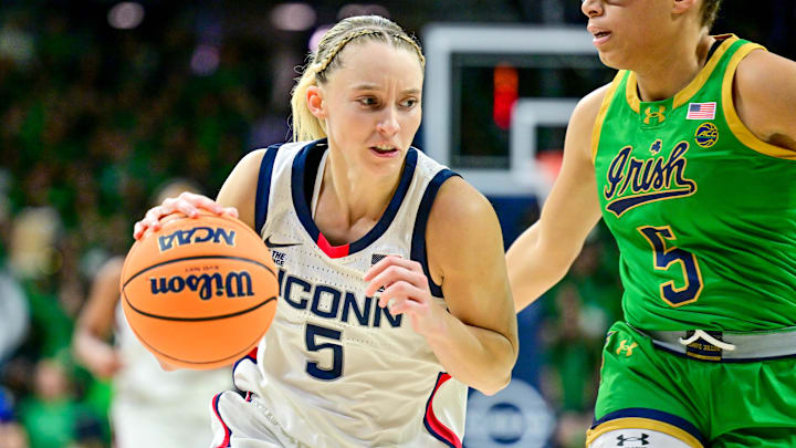 Dec 12, 2024; South Bend, Indiana, USA; Connecticut Huskies guard Paige Bueckers (5) dribbles as Notre Dame Fighting Irish guard Olivia Miles (5) defends in the first half at the Purcell Pavilion. Mandatory Credit: Matt Cashore-Imagn Images