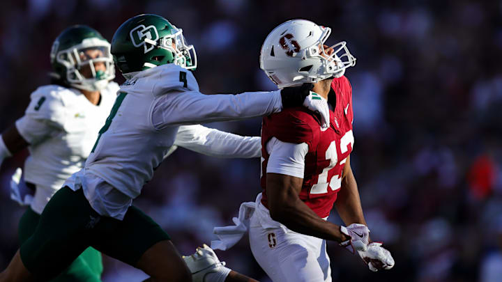 Sep 7, 2024; Stanford, California, USA; Stanford Cardinal wide receiver Elic Ayomanor (13) is held by Cal Poly Mustangs cornerback Kai Rapolla (4) during the second half at Stanford Stadium. Mandatory Credit: Sergio Estrada-Imagn Images Sep 7, 2024; Stanford, California, USA; Stanford Cardinal wide receiver Elic Ayomanor (13) is held by Cal Poly Mustangs cornerback Kai Rapolla (4) during the second half at Stanford Stadium. Mandatory Credit: Sergio Estrada-Imagn Images