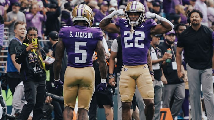 Cam Davis (22) flexes as UW teammate Giles Jackson greets him on game day. 