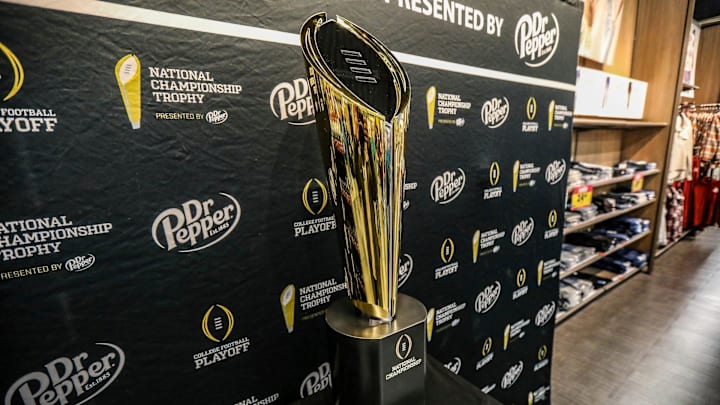 Fans stop to take photos with the College Football National Championship trophy at Meijer in Ypsilanti, Mich. on Thursday, Jan. 11, 2024. The trophy is going on a tour for fans to see presented by Dr. Pepper.