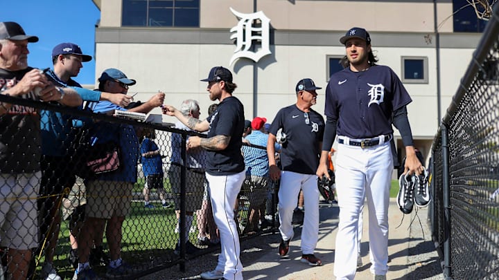 Catcher Eric Hasse signs autographs and takes pictures with fans as pitcher Alex Faedo walks to the