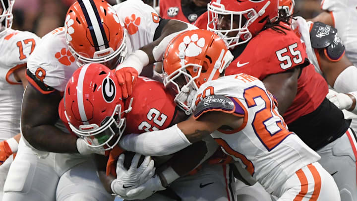 Aug 31, 2024; Atlanta, Georgia, USA; Clemson Tigers corner back Avieon Terrell (20) and defensive tackle Tre Williams (8) tackle Georgia Bulldogs running back Branson Robinson (22) during the first quarter of the 2024 Aflac Kickoff Game at Mercedes-Benz Stadium.