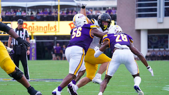 East Carolina Pirates defensive lineman D'Anta Johnson and defensive back Shavon Revel Jr. stops the run by Appalachian State Mountaineers running back Anderson Castle during the first half at Dowdy-Ficklen Stadium. 