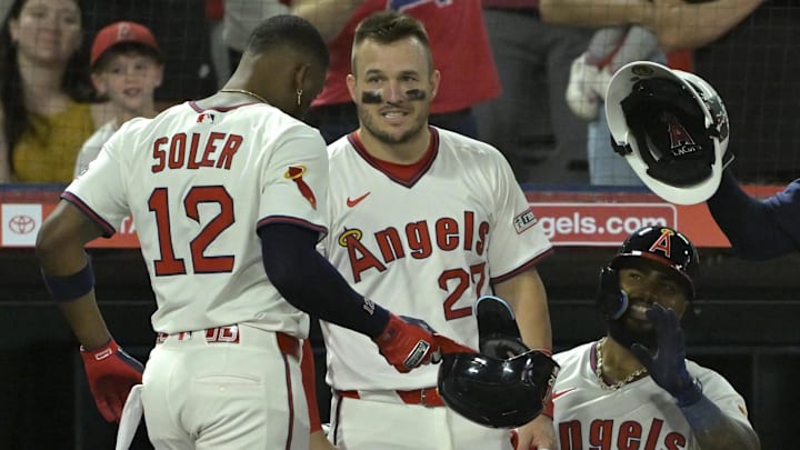 Jul 9, 2025; Anaheim, California, USA;  Los Angeles Angels right fielder Jorge Soler (12) is congratulated by designated hitter Mike trout (27) and second baseman Luis Rengifo (2) after hitting a two-run home run in the eighth inning against the Texas Rangers at Angel Stadium. Mandatory Credit: Jayne Kamin-Oncea-Imagn Images