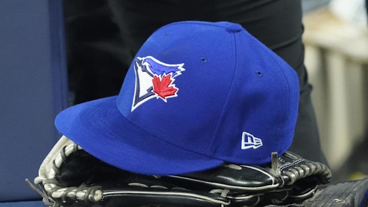 Apr 27, 2024; Toronto, Ontario, CAN; A Toronto Blue Jays hat and glove in the dugout during the third inning against the Los Angeles Dodgers at Rogers Centre. Mandatory Credit: John E. Sokolowski-Imagn Images