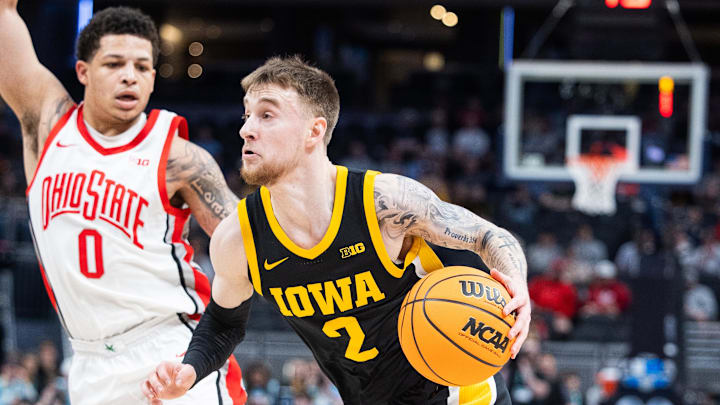 Mar 12, 2025; Indianapolis, IN, USA; Iowa Hawkeyes guard Brock Harding (2) dribbles the ball while Ohio State Buckeyes guard John Mobley Jr. (0) defends in the first half  at Gainbridge Fieldhouse. Mandatory Credit: Trevor Ruszkowski-Imagn Images