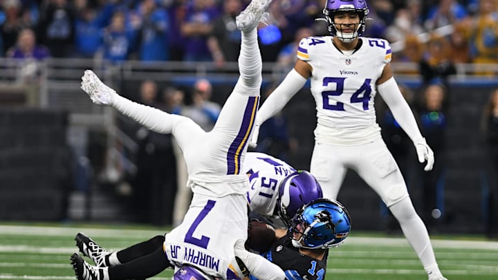 Jan 5, 2025; Detroit, Michigan, USA; Minnesota Vikings linebacker Blake Cashman (51) and cornerback Byron Murphy Jr. (7) tackle Detroit Lions wide receiver Amon-Ra St. Brown (14) after St. Brown caught a pass for a first down in the first quarter at Ford Field. Mandatory Credit: Lon Horwedel-Imagn Images