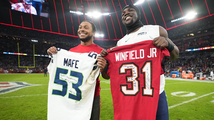 Nov 13, 2022; Munich, Germany; Tampa Bay Buccaneers safety Antoine Winfield Jr. (left) and Seattle Seahawks linebacker Boye Mafe pose with jerseys after an NFL International Series game at Allianz Arena. 