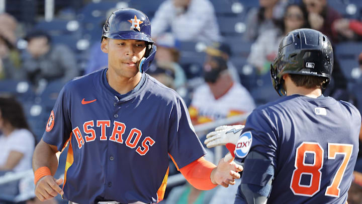 Feb 22, 2025; West Palm Beach, Florida, USA; Houston Astros infielder Cam Smith (left) is congratulated by teammate Tommy Sacco Jr. (87) after scoring a run in the ninth inning against the Washington Nationals at CACTI Park of the Palm Beaches. 