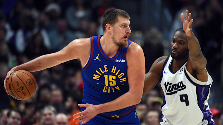 Nov 22, 2025; Denver, Colorado, USA; Denver Nuggets center Nikola Jokic (15) looks to pass the ball against Sacramento Kings forward Precious Achiuwa (9) during the second half at Ball Arena. Mandatory Credit: Christopher Hanewinckel-Imagn Images