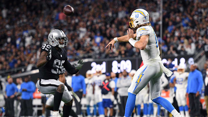 Chargers quarterback Justin Herbert (10) throws a pass over Raiders defensive end Clelin Ferrell (99) in 2022 Chargers quarterback Justin Herbert (10) throws a pass over Raiders defensive end Clelin Ferrell (99) in 2022
