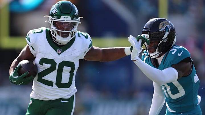 Dec 14, 2025; Jacksonville, Florida, USA; New York Jets running back Breece Hall (20) runs with the ball against Jacksonville Jaguars cornerback Montaric Brown (30) during the first quarter at EverBank Stadium. Mandatory Credit: Morgan Tencza-Imagn Images