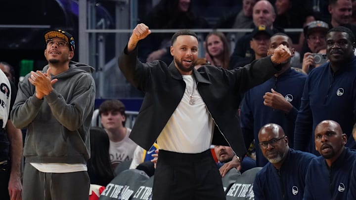 Feb 22, 2026; San Francisco, California, USA;  Golden State Warriors guard Stephen Curry (30) celebrates from the bench next to his brother guard Seth Curry (31) during a game against the Denver Nuggets in the fourth quarter at Chase Center. 