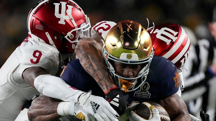 Indiana Hoosiers defensive back Jamier Johnson (9) and defensive back Terry Jones Jr. (12) tackle Notre Dame Fighting Irish running back Jadarian Price (24) during the first half of a game between the Indiana Hoosiers and the Notre Dame Fighting Irish in first round of the College Football Playoff on Friday, Dec. 20, 2024, in South Bend.