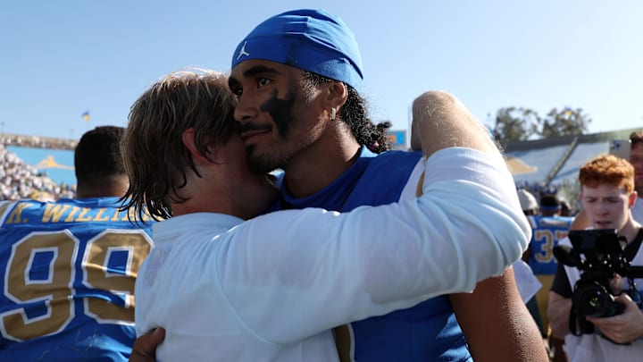 Oct 4, 2025; Pasadena, California, USA;  UCLA Bruins quarterback Nico Iamaleava (9,right) hugs new offensive coordinator Jerry Neuheisel after defeating the Penn State Nittany Lions 42-37 at Rose Bowl. Mandatory Credit: Kiyoshi Mio-Imagn Images