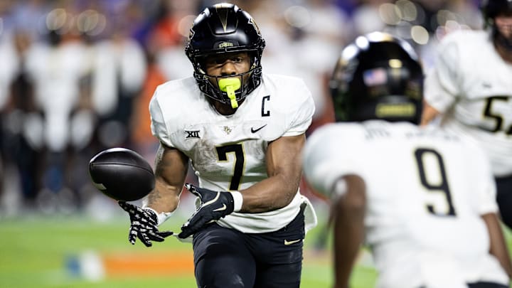 Oct 5, 2024; Gainesville, Florida, USA; UCF Knights running back RJ Harvey (7) flips the ball to wide receiver Ja'Varrius Johnson (9) against the Florida Gators during the first half at Ben Hill Griffin Stadium. Mandatory Credit: Matt Pendleton-Imagn Images