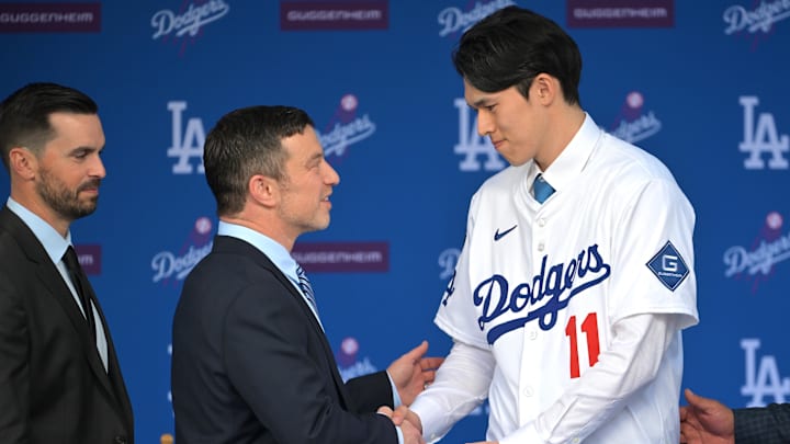 Jan 22, 2025; Los Angeles, CA, USA;  L-R; Brandon Gomes, president of baseball operations and general manager Andrew Friedman shake hands with Los Angeles Dodgers pitcher Roki Sasaki (11) during an introductory press conference at Dodger Stadium. Mandatory Credit: Jayne Kamin-Oncea-Imagn Images  