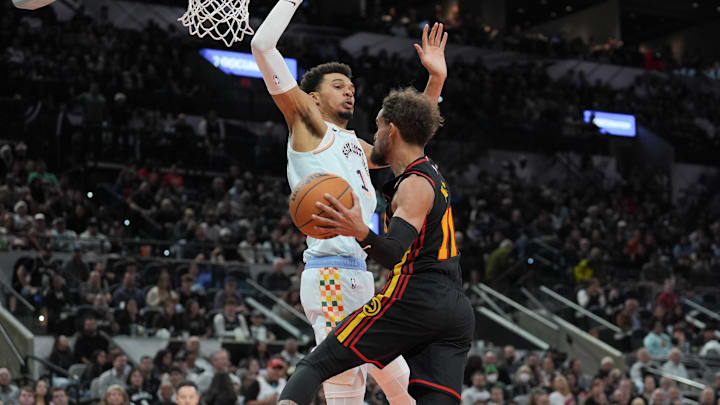 Dec 19, 2024; San Antonio, Texas, USA;  Atlanta Hawks guard Trae Young (11) goes up against San Antonio Spurs center Victor Wembanyama (1) in the second half at Frost Bank Center. Mandatory Credit: Daniel Dunn-Imagn Images