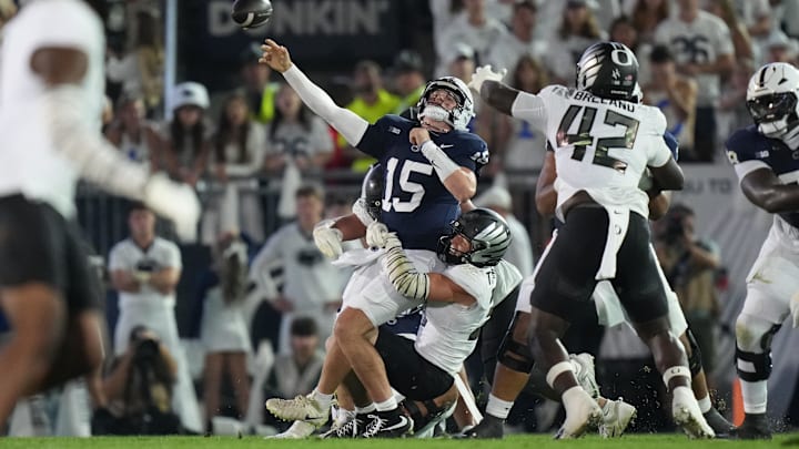 Penn State Nittany Lions quarterback Drew Allar (15) is tackled by Oregon Ducks linebackers Kamar Mothudi (33) and Teitum Tuioti (44) during the second quarter at Beaver Stadium. 