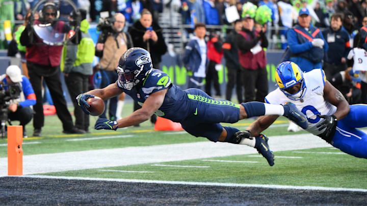 Jan 25, 2026; Seattle, WA, USA; Seattle Seahawks running back Kenneth Walker III (9) reaches for a touchdown against Los Angeles Rams linebacker Byron Young (0) in the first half in the 2026 NFC Championship Game at Lumen Field. Mandatory Credit: Steven Bisig-Imagn Images