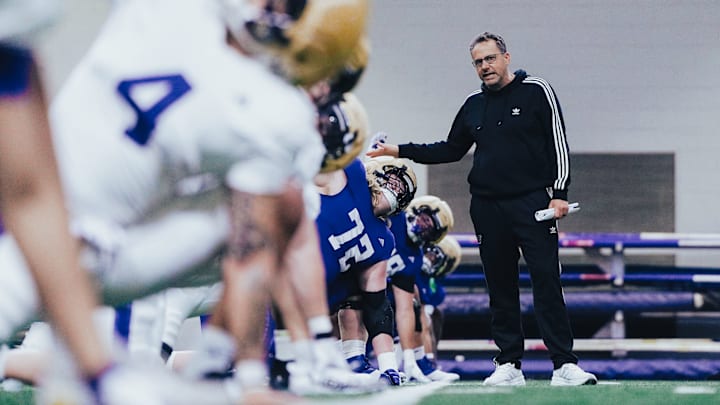 UW coach Jedd Fisch goes down the line, stopping at John Mills (72).