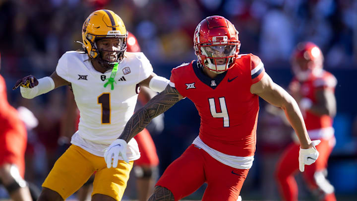 Nov 30, 2024; Tucson, Arizona, USA; Arizona Wildcats wide receiver Tetairoa McMillan (4) against Arizona State Sun Devils defensive back Keith Abney II (1) during the Territorial Cup at Arizona Stadium. Mandatory Credit: Mark J. Rebilas-Imagn Images Nov 30, 2024; Tucson, Arizona, USA; Arizona Wildcats wide receiver Tetairoa McMillan (4) against Arizona State Sun Devils defensive back Keith Abney II (1) during the Territorial Cup at Arizona Stadium. Mandatory Credit: Mark J. Rebilas-Imagn Images