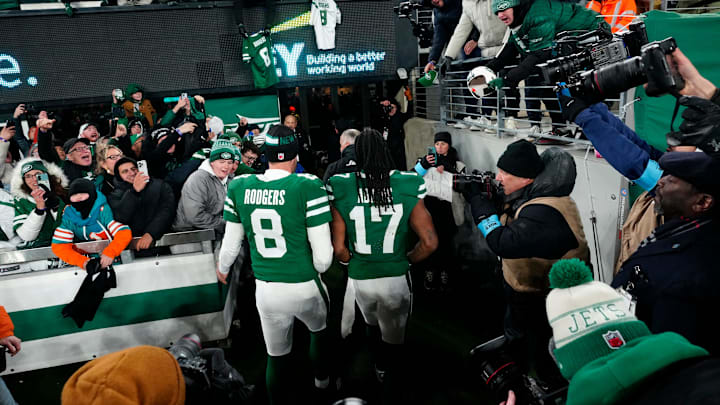 New York Jets quarterback Aaron Rodgers (8) and New York Jets wide receiver Davante Adams (17) step off the field to cheering fans, Sunday January 5, 2025, in East Rutherford.
