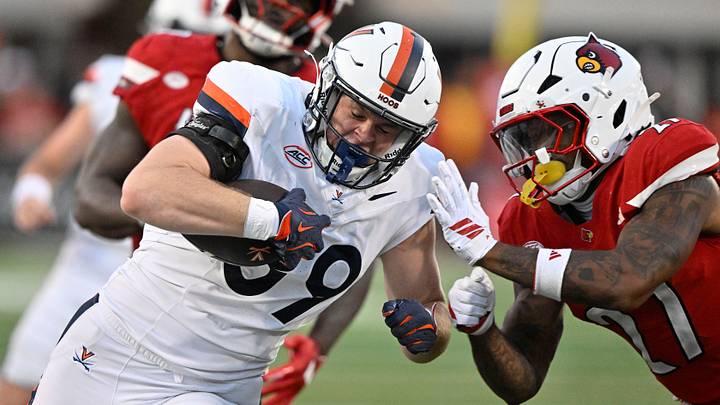 Oct 4, 2025; Louisville, Kentucky, USA; Virginia Cavaliers tight end John Rogers (89) runs the ball against Louisville Cardinals defensive back JoJo Evans Jr. (27) during the second half at L&N Federal Credit Union Stadium. Virginia defeated Louisville 30-27. Mandatory Credit: Jamie Rhodes-Imagn Images