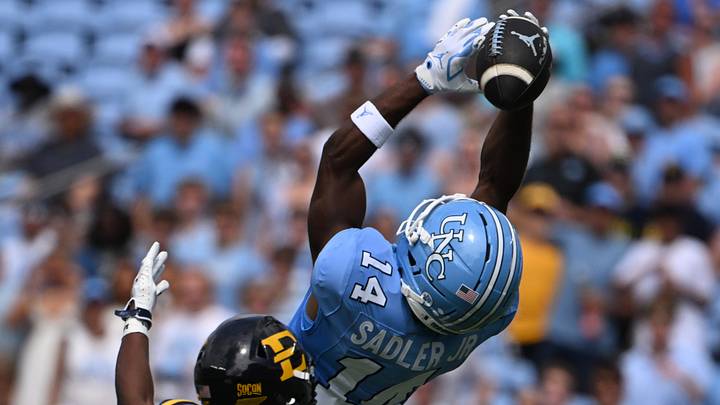 Sep 12, 2026; Chapel Hill, North Carolina, USA; North Carolina Tar Heels wide receiver C.J. Sadler (14) attempts to make a catch as ETSU Buccaneers defensive back CJ Gilmore (15) defends in the first quarter at Kenan Stadium. Mandatory Credit: Bob Donnan-Imagn Images