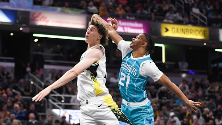 Dec 8, 2024; Indianapolis, Indiana, USA; Charlotte Hornets guard Isaiah Wong (21) fouls Indiana Pacers forward Johnny Furphy (12) on a shot attempt during the first half at Gainbridge Fieldhouse. Mandatory Credit: Robert Goddin-Imagn Images Dec 8, 2024; Indianapolis, Indiana, USA; Charlotte Hornets guard Isaiah Wong (21) fouls Indiana Pacers forward Johnny Furphy (12) on a shot attempt during the first half at Gainbridge Fieldhouse. Mandatory Credit: Robert Goddin-Imagn Images